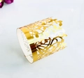 Close-up of golden laser-cut hollow rings with intricate leaf and vine patterns - Reflective Gold