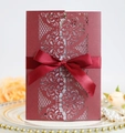 Detailed laser-cut burgundy wedding invitation with elegant satin bow on luxury plate - Dark Red