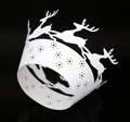 Macro detail of laser-cut white paper cupcake wrappers with reindeer and star patterns - White