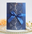Detail of navy blue laser cut floral invitation with silk ribbon on decorative plate - Magic Blue