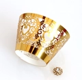 Close-up of golden laser-cut cupcake wrapper with heart patterns and rhinestone detail - Reflective Gold