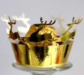 Close-up of golden laser-cut Christmas cupcake wrappers with reindeer patterns - Reflective Gold