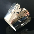 Macro shot of silver laser-cut rose hollow cupcake wrappers for wedding decor - Reflective Silver