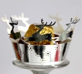 Primer plano de envoltorios de cupcake plateados cortados con láser con renos y estrellas de Navidad - Plata Reflectante