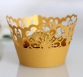 Macro shot of gold laser-cut cupcake wrapper with intricate mandala patterns on pearl paper - Gold