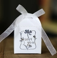 Detail of white hollowed-out candy box with LOVE YOU text and elegant white ribbon bow - White