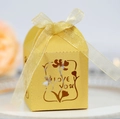 Detailed view of a gold hollow-out wedding candy box with Love You engraving and ribbon - Gold