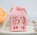 Primer plano de caja rosa cortada con láser para bodas con cinta sobre plato blanco - Rosa
