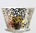 Close-up of silver laser-cut cupcake wrapper with floral pattern and golden chocolate - Reflective Silver