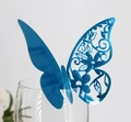 Detailed laser-cut hollow blue butterfly place card attached to a transparent glass rim - Reflective Blue