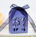 Nahaufnahme der violetten Laserschnitt-Bonbonschachtel mit Blumenmuster und blauer Schleife - Saphirblau