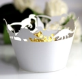 Close-up of laser-cut white dinosaur cupcake wrappers with elegant hollow patterns - White