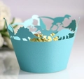Close-up of laser-cut dinosaur cupcake wrapper in light teal with a golden chocolate - Tiffany Blue
