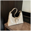 Creamy beige crescent shoulder bag in glossy patent leather with a large silver buckle detail - White