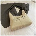 Detail der gewebten Hobo-Tasche aus Stroh mit beiger Textur und schwarzem Schultergurt - Schwarz