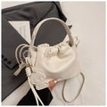 Detail der cremeweißen Leder-Eimertasche mit Hundeanhänger und eleganter Gravur - Einheitsgröße / Gebrochenes Weiß