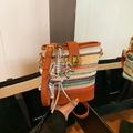 Colorful striped woven bucket bag with leather trim and star charms in a warm scene - Multicolor With Charm