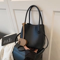 Schwarze Bucket Bag mit Litschistruktur, braunem Elefantenanhänger und Tragegriffen - Schwarz