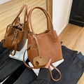 Braune Beuteltasche aus Leder mit Kieselstruktur, Henkeln und Elefantenanhänger - Braun