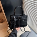 Glossy black patent leather handbag with adjustable strap and rivet details - Black