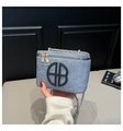 Detalle de bolso cuadrado azul brillante con herrajes dorados y diseño de logo circular - Azul