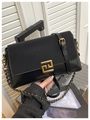 Detalle de bolso bandolera negro con diseño de patchwork de cuero y cierre geométrico dorado - Negro