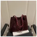 Détail du sac cabas à imprimé léopard avec anses tressées posé sur un livre blanc - Sans Pendentif / Rouge