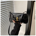 Detalle de bolso baguette en charol negro con cierre metálico rectangular dorado - Negro