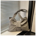 Close-up detail of grey bow-shaped tote bag with soft pleated fabric and wide straps - Gray
