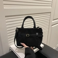Black suede tote bag with golden buckle and adjustable strap in a handheld view - Black