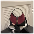 Détail de couture en daim bordeaux et cuir noir avec un fermoir rotatif en métal doré - Rouge