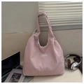 Detailed macro view of pink corduroy tote bag texture with fashion label on white table - Pink