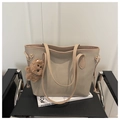 Dettaglio della borsa tote kaki con ciondolo a forma di orsetto su una sedia moderna - Cachi Con Pendente