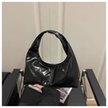 Primer plano detallado de un bolso de media luna negro brillante con acabado de charol - Negro