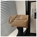Detailed view of the brown leather texture and metal twist lock on a shoulder bag - Khaki