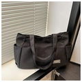 Detailansicht der Seitentasche und des grauen 'FASHION' Labels auf der schwarzen Nylontasche - Schwarz
