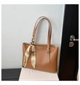 Detail einer braunen Leder-Tote mit Seidenschal-Griff und geprägtem Fashion-Logo - Braun