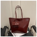 Dettaglio della borsa tote in pelle verniciata bordeaux con portamonete su sedia moderna - Rosso