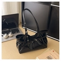 Close-up of black glossy patent leather tote bag with silver buckle and office props - Coffee