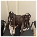 Close-up of vintage brown leather shoulder bag featuring silver rivets and eyelet strap - Coffee