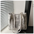 Detailed macro shot of a hollow star pattern tote bag with brand leather tag and chain - White Without Charm