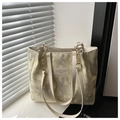 Detail of star and moon printed beige tote bag with gold chain strap on window sill - Yellow Without Charm