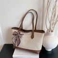 Canvas tote bag with leather trim and silk scarf bow on books in a French style setting - Brown