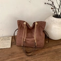 Retro brown suede bucket bag with chain strap on a wooden table in a vintage room - No Pendant / Brown