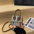 Multicolor woven crossbody bag with brown leather handle and detachable strap on beige steps - Brown