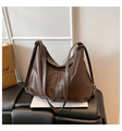 Detailed view of dark brown soft leather shoulder bag with circular embossed logo - Coffee