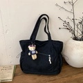 Detalle del bolso tote de pana negra con cordones laterales y un colgante de oso - Negro Con Colgante