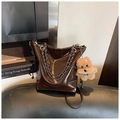 Detail of dark brown glossy leather bucket bag with silver chain and plush puppy charm - Coffee with Pendant