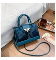 Details der dunkelblauen Handtasche mit Krokodilmuster und elegantem Goldverschluss - Blau