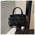 Detailaufnahme einer schwarzen Wildlederimitat-Tasche mit dekorativer Gürtelschnalle - Schwarz